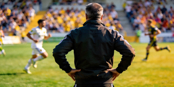 足球教练在场边指挥比赛的背影